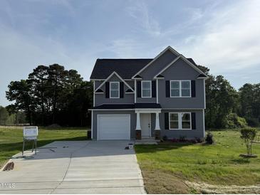 Charming two-story home with gray siding, black shutters, and a well-manicured front lawn at 63 Coharie Dr, Lillington, NC 27546