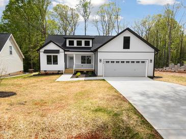 Charming two-story home with white siding, a two-car garage, and a well-manicured front yard at 648 Shawnee Dr, Louisburg, NC 27549