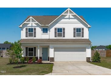 Charming two-story home with a well-maintained lawn, attached garage, and inviting facade at 76 Arlie Ln, Lillington, NC 27546