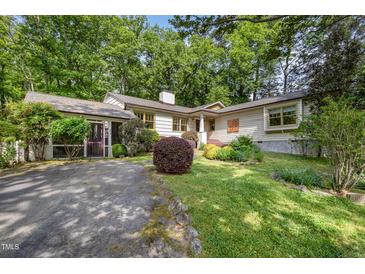 Charming one-story home features a landscaped front yard with mature trees and a welcoming entrance at 804 Old Mill Rd, Chapel Hill, NC 27514