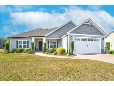 Charming single-Gathering home with manicured lawn, inviting front door, and attached two-car garage at 93 Fallingbrook Dr, Kenly, NC 27542