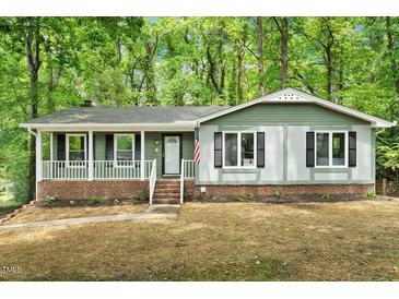 Charming single-story home with a brick foundation, green siding, and a cozy front porch at 104 Argyle Ct, Garner, NC 27529