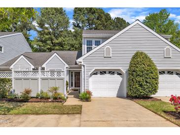 Charming home featuring a one-car garage, gray siding, and beautifully manicured landscaping at 105 Breakers Pl, Cary, NC 27511