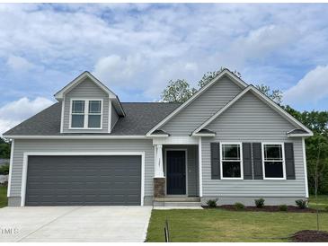 Charming home with gray siding, black shutters, gray garage door, and well-manicured lawn at 127 Oakfield Trace Dr, Four Oaks, NC 27524
