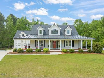 Charming home featuring a metal roof, inviting front porch with columns, and a well-maintained lawn at 140 Crystal Pl, Benson, NC 27504
