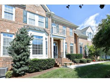 Charming brick townhome with well-maintained landscaping, a balcony, and a welcoming front entrance at 2318 Carriage Oaks Dr, Raleigh, NC 27614