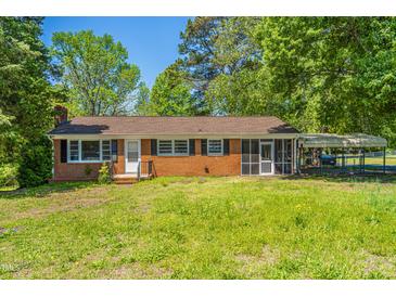 Quaint brick home with a screened porch and covered parking surrounded by mature trees at 2500 Courtland Dr, Sanford, NC 27330