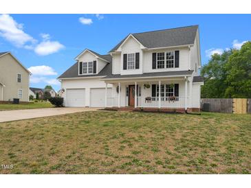 Charming two-story home featuring a welcoming front porch and attached two-car garage at 281 Highland Forest Dr, Sanford, NC 27332