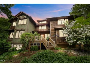Charming multi-level home with wooden deck, lush greenery, and flowering shrubs at 2917 Ericka Dr, Hillsborough, NC 27278