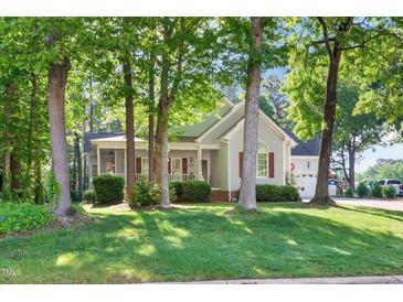 Charming home with mature trees, lush green lawn, and inviting front porch at 304 Parkridge Dr, Clayton, NC 27527