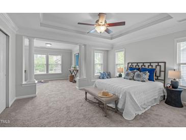 Spacious main bedroom featuring large windows, a tray ceiling, and a seating area at 3148 Rapid Falls Rd, Cary, NC 27519