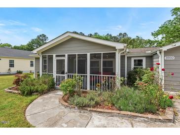 Charming home featuring a screened porch and manicured garden beds at 3902 Booker Ave, Durham, NC 27713