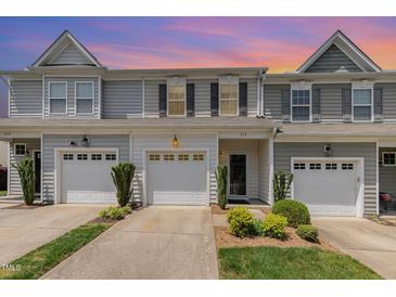 Charming townhome featuring a one-car garage, inviting front entrance, and meticulously landscaped yard at 412 Stone Flower Ln, Raleigh, NC 27603