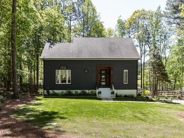Charming home with a well-manicured lawn and a lovely exterior, surrounded by mature trees at 4521 Briarglen Ln, Holly Springs, NC 27540