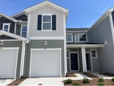 Charming two-story townhouse featuring a one-car garage and neat landscaping under a clear sky at 503 Eastwood St, Durham, NC 27703