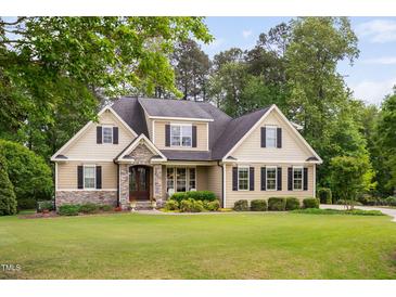Charming home featuring manicured lawn and stone accents enhance curb appeal at 5209 Thistleby Rd, Fuquay Varina, NC 27526