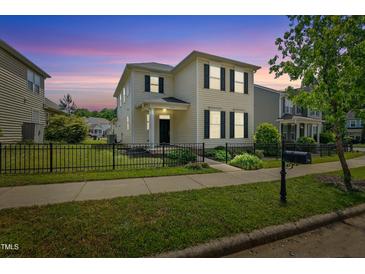 Charming two-story home with black shutters, black fence, and lush green lawn at 704 Moonbeam Dr, Raleigh, NC 27603
