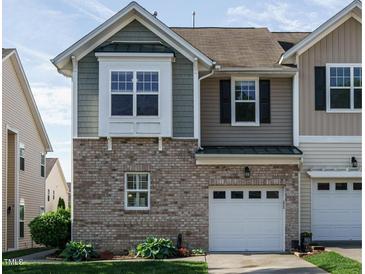 Two-story townhome with brick facade, attached one-car garage, and well-maintained front lawn at 7229 Terregles Dr, Raleigh, NC 27617