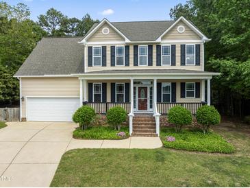 Charming two-story home with a manicured lawn and inviting front porch at 84 N Hadrian Ct, Clayton, NC 27520