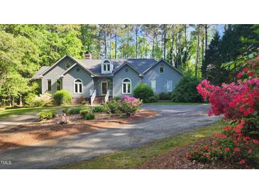 Charming home with mature landscaping, flowering bushes and a circular driveway at 113 Colonial Dr, Wendell, NC 27591