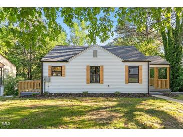 Charming home featuring a new roof and stylish wooden shutters, complemented by a lush green lawn at 1513 Fairfax Rd, Durham, NC 27701