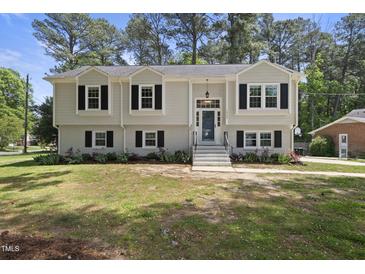 Charming home featuring a well-manicured lawn, updated exterior, black shutters, and a welcoming front entrance at 1532 Cone Ave, Apex, NC 27502