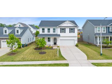 Beautiful two-story home with a well-manicured lawn and a long driveway leading to the garage at 176 Belleforte Park Cir, Garner, NC 27529