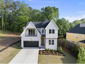 Charming two-story home with landscaped yard and a black garage door at 1904 French Dr, Raleigh, NC 27612