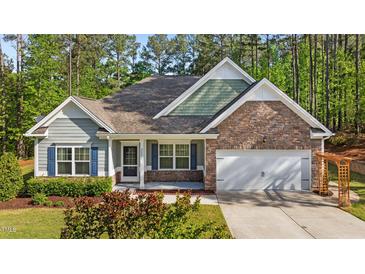 Charming single-Gathering home featuring a stone facade, attached two-car garage and welcoming front porch at 2005 Delphi Way, Wake Forest, NC 27587