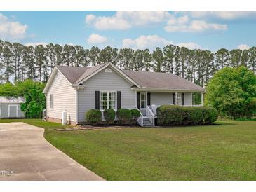 Charming single-story home with a well-manicured lawn, inviting curb appeal, and a concrete driveway at 205 Twin Oaks Dr, Angier, NC 27501