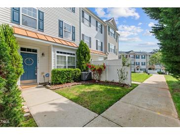 Charming townhouse with tidy front yard, landscaping, and welcoming blue door at 2210 Raven Rd # 105, Raleigh, NC 27614