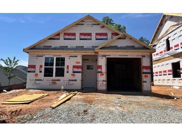 New construction home featuring an attached garage and bright window, awaiting personalization and finishing touches at 245 Bluejay St, Clayton, NC 27520