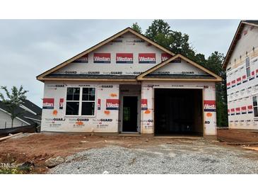 New construction home with a two-car garage and covered entry awaiting its finishing touches at 245 Bluejay St, Clayton, NC 27520