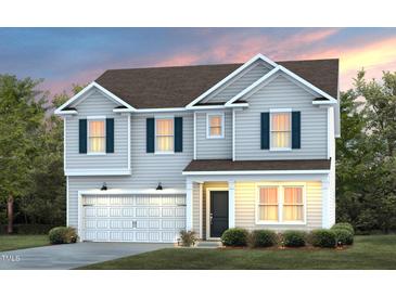 Charming two-story home boasts a manicured lawn, attached garage, and inviting front porch at 3233 Pelican Ln, Durham, NC 27703