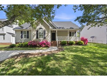 Charming single-story home with a welcoming front porch and lovely landscaping including pink azaleas at 3519 Streams Of Fields Dr, Raleigh, NC 27604