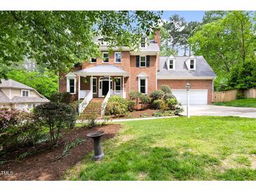 Charming brick two-story home with a well-manicured lawn and lush landscaping, offering classic curb appeal at 4215 Cobscook Dr, Durham, NC 27707