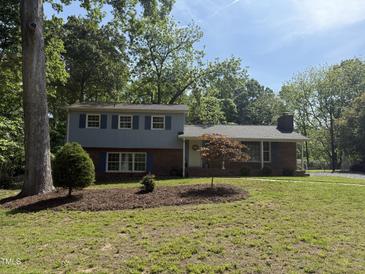 Charming two-story home with brick accents, blue shutters, and a well-manicured lawn at 5026 Gatewood Drive Dr, Durham, NC 27712