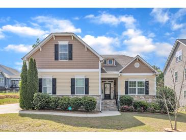 Charming two-story home with manicured lawn and stone accents, offering classic curb appeal at 615 Prides Crsg Xing, Rolesville, NC 27571