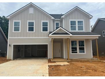 Two-story home with light gray siding, black roof, and an attached garage at 788 Old Station Pointe, Angier, NC 27501
