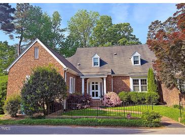 Charming brick home with well-manicured lawn, mature trees and manicured shrubbery enhancing the curb appeal at 8 Greenside Ct, Durham, NC 27707