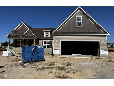 New construction two-story home showing siding and garage, with a large blue trash bin in the front at 835 Olive Branch Dr, Smithfield, NC 27577