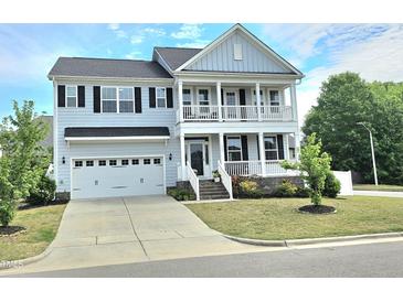 Charming two-story home featuring a welcoming porch, attached garage, and well-manicured lawn at 1002 Dogwood Bloom Ln, Knightdale, NC 27545