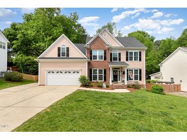 Charming two-story home with brick accents, attached garage, and well-manicured lawn at 1003 Fairfax Woods Dr, Apex, NC 27502