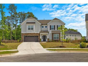 Charming two-story home with stone accents, lush lawn, and an inviting driveway at 1005 Whispering Creek Ct, Knightdale, NC 27545