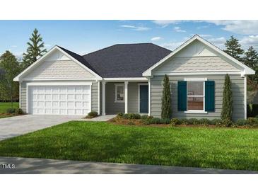 Charming one-story home featuring a two-car garage, manicured lawn, and classic architectural details at 102 Gobbler Dr, Smithfield, NC 27577
