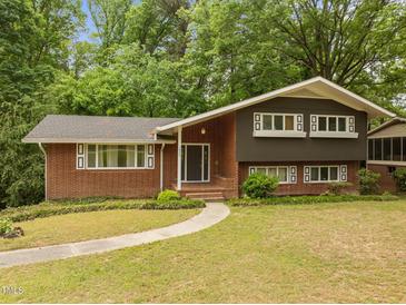 Charming brick home featuring a manicured lawn, inviting walkway, and well-maintained landscaping at 1024 Chalmers St, Durham, NC 27707