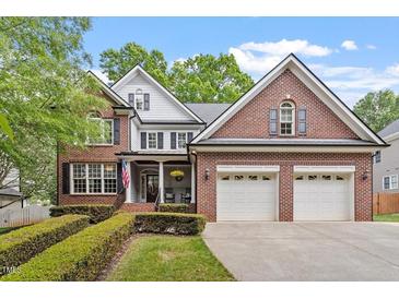 Charming brick home with a manicured lawn and an attached two-car garage at 121 Cobblepoint Way, Holly Springs, NC 27540