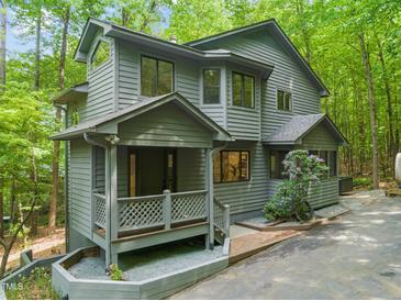 Charming two-story home featuring a welcoming front porch, natural landscaping, and unique architectural details at 1213 Blackwood Mountain Rd, Chapel Hill, NC 27516