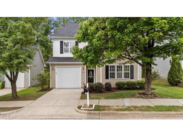 Charming two-story home with beige siding, black shutters, attached garage, and manicured landscaping at 125 Occidental Dr, Holly Springs, NC 27540