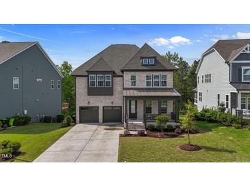 Charming two-story home with brick facade, covered front porch, and well-manicured lawn at 1632 Ferntree Ct, Morrisville, NC 27560
